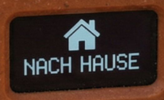 OLED-Display mit Haus-Symbol und dem Text NACH HAUSE